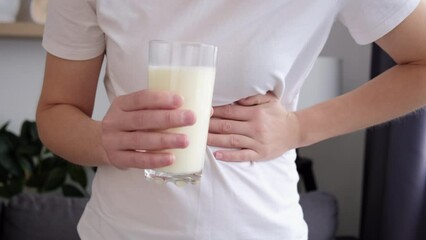 Healthcare and medical concept. Close up of unhealthy young caucasian woman holding glass of milk having bad stomach ache because of lactose intolerance. Health problem with dairy food products 