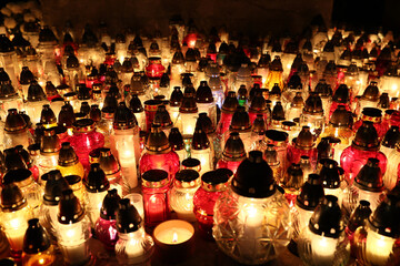 Znicze na grobie osoby bliskiej świeci podczas święta zmarłych wieczorem. Światło.