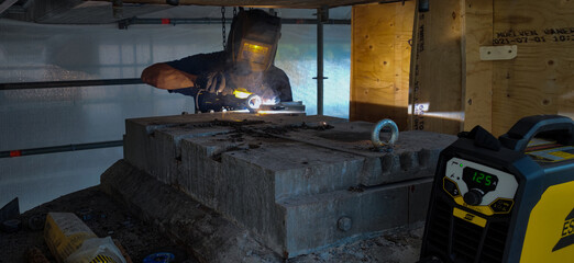 A Swedish welder working on removal of bridge bearings under Nockebyhov bridge Stockholm, Sweden.