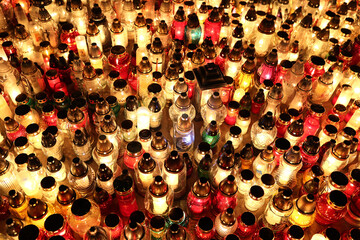 Znicze na grobie osoby bliskiej świeci podczas święta zmarłych wieczorem. Światło. - obrazy, fototapety, plakaty
