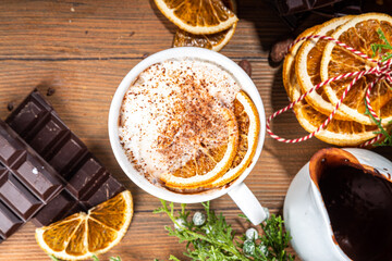 Orange hot cocoa drink. Homemade winter Christmas dark spicy hot chocolate with dried orange, with chocolate and orange slices on wooden cozy background