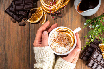 Orange hot cocoa drink. Homemade winter Christmas dark spicy hot chocolate with dried orange, with chocolate and orange slices on wooden cozy background