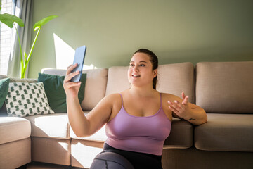 Happy overweight woman gesturing and having smartphone video call