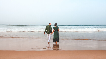 A young lovely attractive romantic Indian couple looking at each other, embracing, smiling,...