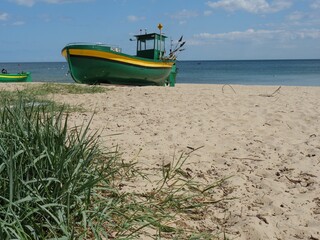 Bemaltes gelbgrünes Boot vor Anker am Ufer der Ostsee in Sopot, Polen