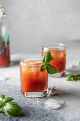 Tomato juice or Bloody Mary iced cocktail with bazil leaves in two glasses for drink menu with text space