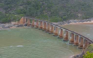 Fototapeta na wymiar Eisenbahnbrücke über den Krokodil Fluss - Kaaimans River an der Küste vom Indischer Ozean Südafrika