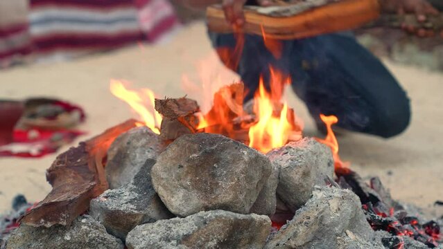 Bonfire for heating volcanic stones. A man puts firewood in a fire that heats up volcanic stones for the Mexican rite of Temazcal. The video was shot not far from the city of Cancun in Mexico.