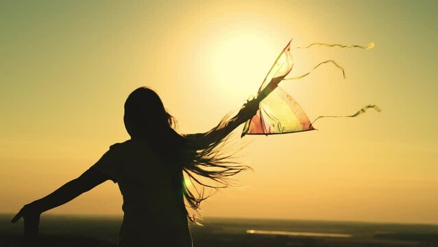 kite. colored rainbow kite hands girl with long hair. happy family. chidhood dream. girl park sunset playing with kite. child teenager journey. fantasy child. concept kite wind. play game nature.