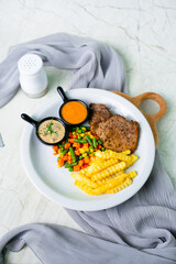 Beef steak served with two variant sauces, potato and vegetables. white background. brazilian typical food.