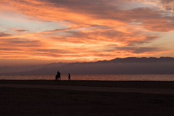 couple walking on the beach at sunset