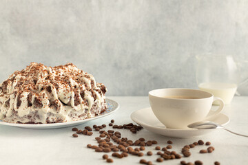 Coffee with cream in a white set with coffee beans, cream cake. Drink on a light gray background.