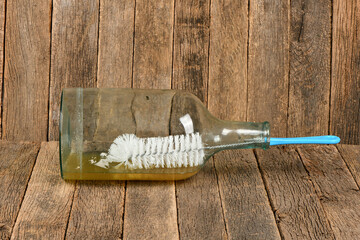 Wire brush for cleaning bottles on dark wood background
