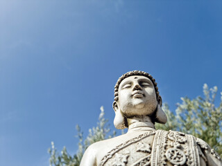 Buddha bust in the foreground with the sky in the background