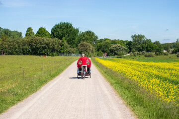 A woman in red rides a bicycle on a contry road. High quality photo