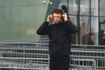 Attractive man listening to music via smartphone in the city