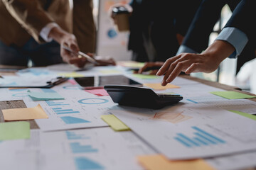 Business people in a meeting and using a calculator to calculate, plan, analyze, create graphs and charts to show business growth to plan new business expansions in the future.