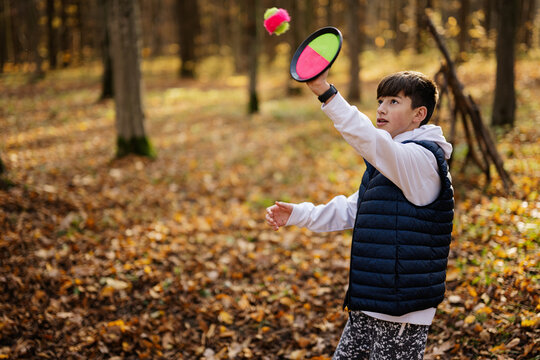 Autumn outdoor portrait of boy play with catch and toss ball game.