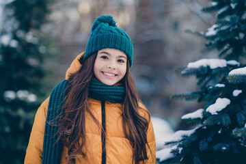 Photo of pretty cheerful school girl dressed outwear coat smiling walking snowy pine countryside forest © deagreez