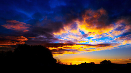 Blazing dramatic sunrise cloudscape at Twilight over southwestern wilderness village