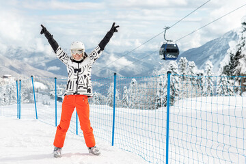 Portrait young adult happy beautiful female skier woman show peace hands up gesture stand on slope...