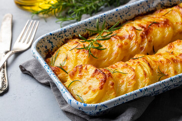 Potato gratin - graten (baked potatoes with cream and cheese) with rosemary and forks (Turkish...