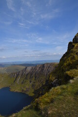 a view looing down in the crater of Cadair Idris with a mountain view behind it