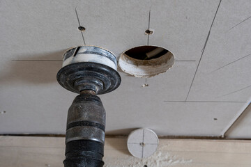 Dusty drilling bit after drilling hole in drywall. Drilling bit connected on electrical drilling...