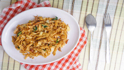 Delicious fried flat rice noodle or char kway teow or kwetiau with egg and vegetables. Indonesian street food
