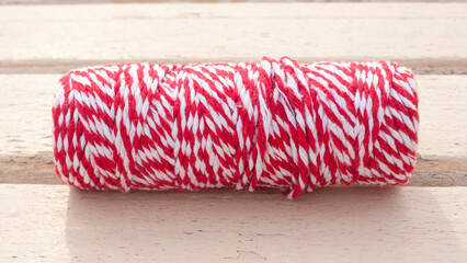 Rollo de cuerda blanca y roja sobre madera blanca