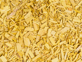 Yellow decorative sawdust for finishing flowerbeds in the park - background