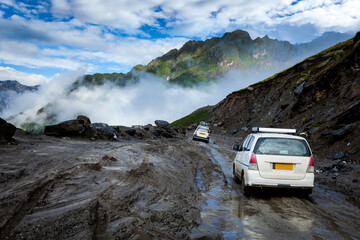Cars on bad road in Himalayas. Near Rohtang La pass, Himachal Pradesh, India