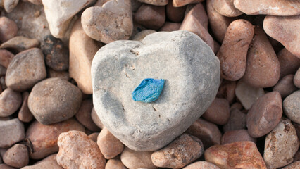 Trozo de plástico azul sobre piedras en playa