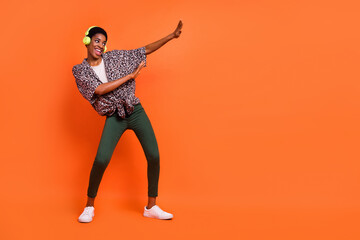 Full length body size view of attractive cheery slim trendy girl listening hit dancing isolated over vivid orange color background