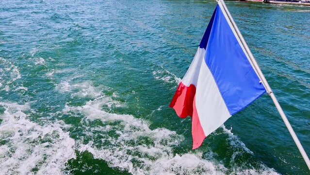 French flag close-up on the boat over river water