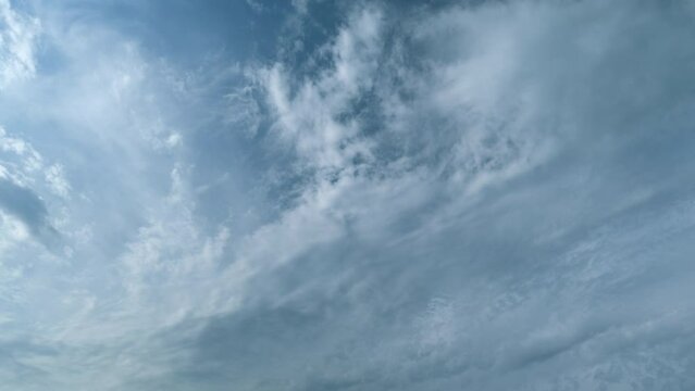 Sky with several layers of clouds moving in different directions. Sun rays at sunshine day. Timelapse.