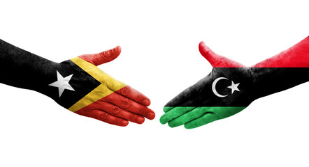 Handshake between Libya and Timor Leste flags painted on hands, isolated transparent image.