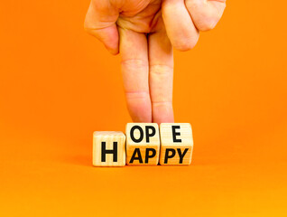 Hope and happy symbol. Concept words Hope and Happy on wooden cubes. Beautiful orange table orange background. Businessman hand. Business hope and happy concept. Copy space.