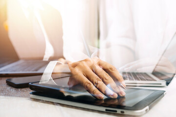 businesswoman hand working with laptop computer, tablet and smart phone in modern office with virtual icon diagram at modernoffice in morning light