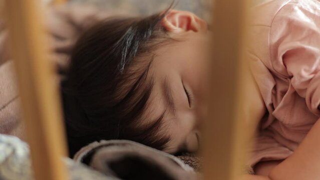 Asian baby sleeping in her crib peacefully. Tight dolly shot. 4K25p