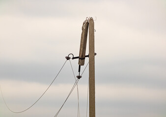 Broken electrical post in Kharkiv region, Ukraine. Electric wire of a broken high voltage pole is...
