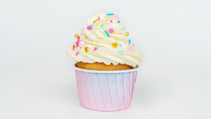 Vanilla muffin in a pink gradient paper cup on a light gray background. Cupcake with buttercream...
