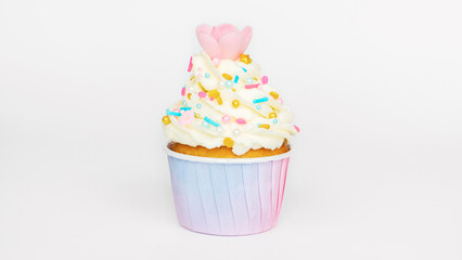 Cupcake decorated with buttercream with gold sprinkling and waffle flower on a light background. Vanilla muffin in a pink gradient paper cup close-up. Sweet treat and desserts for kids parties.