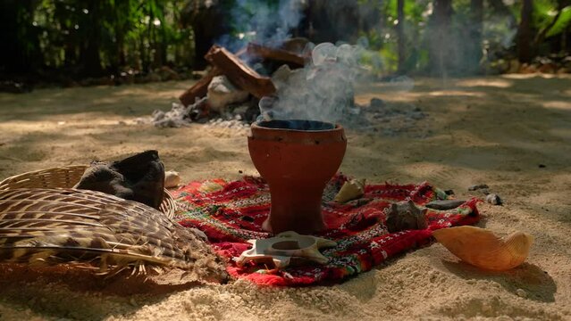 Temazcal Bowl  for the Mexican steam bath Temazcal. Clay bowl from which smoke enters. In the background, a fire is burning, in which volcanic coal is heated for the Mexican steam bath - Temazcal