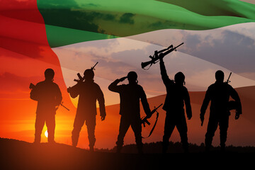 Silhouettes of soldiers on background of UAE flag and the sunset or the sunrise. Concept of national holidays. Commemoration Day.