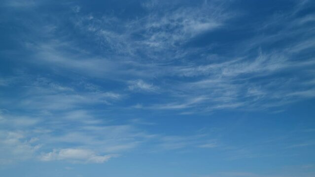 Blue sky with white cirrus clouds. Sunny background, blue sky with white cirrus clouds. Timelapse.