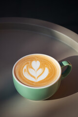 Cup of cappuccino on a gray table under evening light