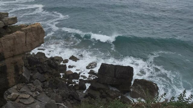 Oleaje fuerte golpea las rocas en la costa c&aacute;ntabra un d&iacute;a nublado. V&iacute;deo en 4k