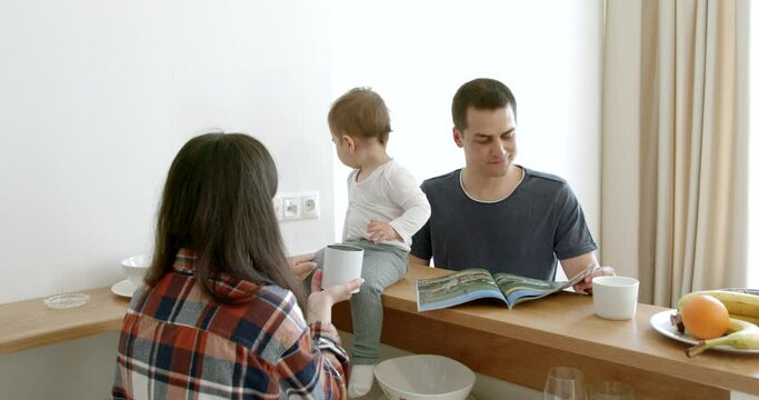 Young cute family with little daughter have breakfast