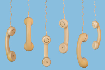 Many old telephone handsets from rotary landlines hanging from cords on blue background. Plastic...